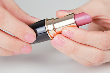 Image showing Hands hold lipstick - a close up