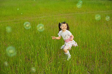 Image showing Happy little girl among soap bubbles