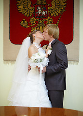 Image showing Newly married kiss under Russian arms