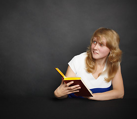 Image showing Amusing girl with book in dark