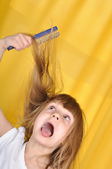 Image showing child having problem with brushing her hair