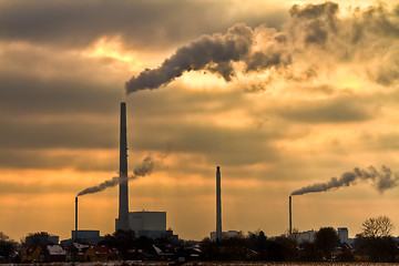 Image showing Power plant with burning yellow sky behind