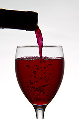 Image showing red wine pouring down from a wine bottle