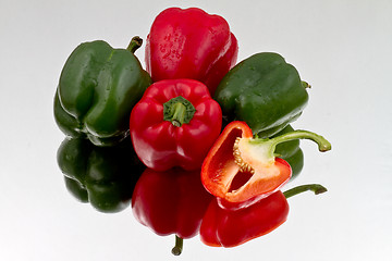 Image showing Red and green bell peppers on reflective bacground