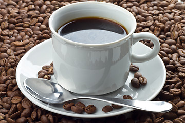 Image showing Coffee beans in white cup on saucer with spoon