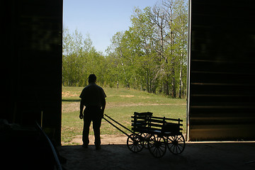 Image showing man and small wagon in silhouette