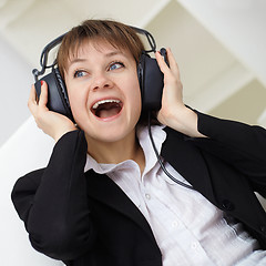 Image showing Ð¡heerful woman singing in ear-phones