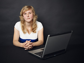 Image showing Woman sits at table with computer