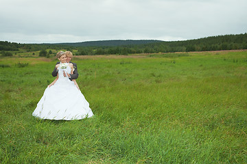 Image showing Groom embraces the favorite bride in field