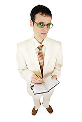 Image showing Young businessman in light suit writes in notebook