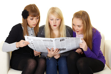 Image showing Three young girls reading newspaper