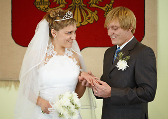 Image showing Happy newlyweds wear wedding ring
