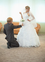 Image showing Groom with bride funny pose in hall