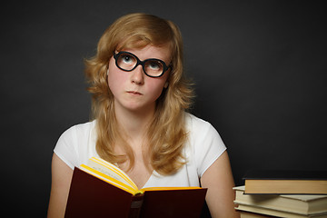 Image showing Well-read woman looks through spectacles