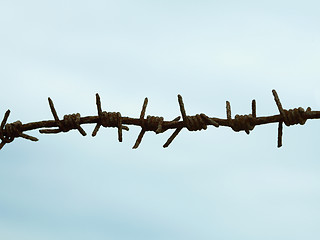 Image showing Ancient rusty barbed wire against sky