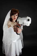 Image showing Serious bride take aim with a pistol