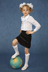 Image showing Schoolgirl put foot on globe