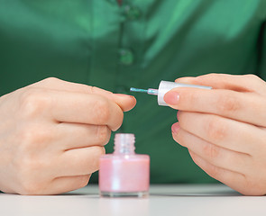 Image showing Woman covers nail varnish - close-up of hands