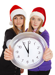 Image showing Two girls in New Year's caps with clock