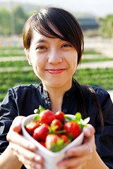 Image showing smile girl give you bowl of strawberries