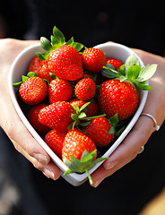 Image showing strawberries in heart shape bowl with hands