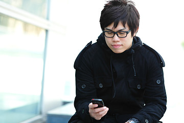 Image showing casual asian man sms on cell phone