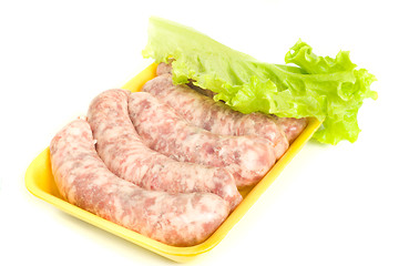 Image showing Uncooked Sausages and salad leaf