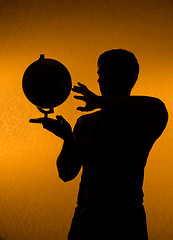 Image showing Discover the world - silhouette of man holding globe