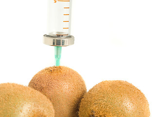 Image showing GMO - kiwi with sticked aged syringe on white