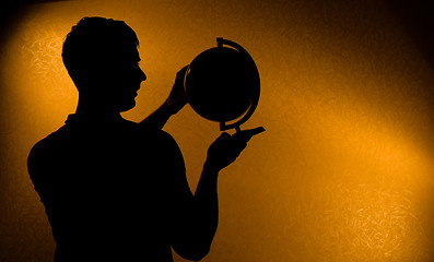 Image showing Silhouette of man holding globe