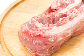 Image showing Raw pork meat on round hardboard