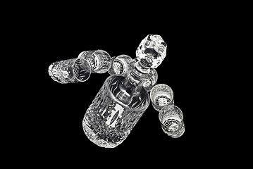 Image showing Crystal decanter with jiggers for alcoholic beverage over black 