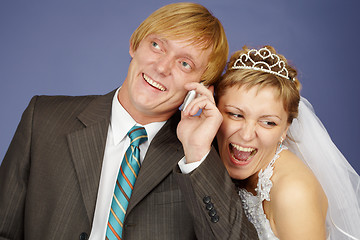 Image showing Happy bride and groom is congratulated by phone