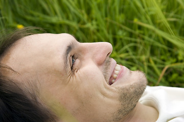 Image showing The man lies on a grass