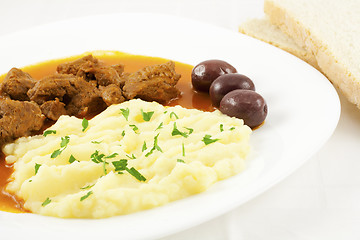 Image showing Goulash with potato puree, olives and bread