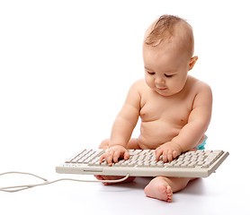 Image showing Little child is typing on keyboard