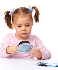 Image showing Girl is looking at euro banknote using magnifier