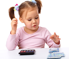 Image showing Little girl plays with money