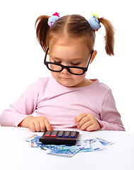 Image showing Little girl plays with money