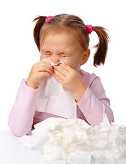 Image showing Little girl blows her nose