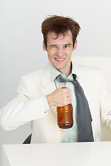 Image showing Cheerful guy in a white jacket with bottle of beer