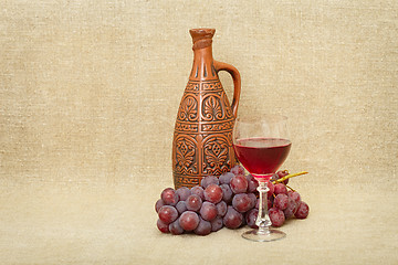 Image showing Still-life from a clay bottle, grapes and wine