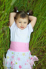 Image showing Little girl has rest in grass