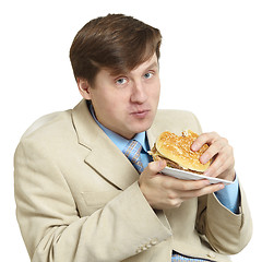 Image showing Funny businessman eats a sandwich isolated on a white