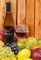 Image showing Wine and fruits on background of wooden wall