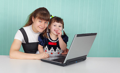 Image showing Mom and daughter playing with laptop