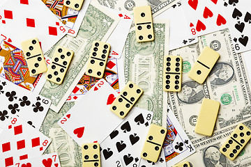 Image showing Dominoes are scattered on cards and money