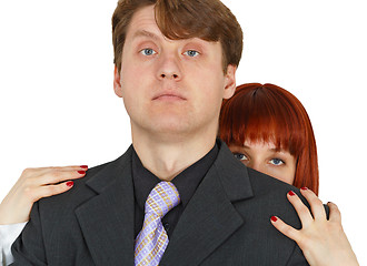 Image showing Young woman hides behind big shoulders of man