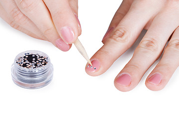 Image showing Female hands. Gluing a paste on nail.
