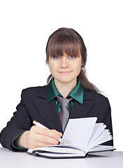 Image showing Young woman - student does records in notebook